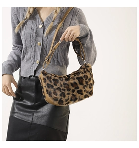 Detail of plush leopard print shoulder bag featuring textured faux fur and brown leather strap