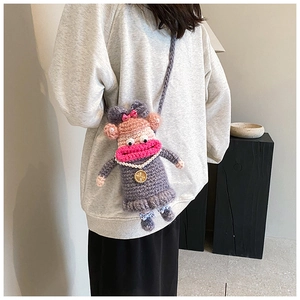 Détail du sac poupée au crochet violet avec nœud rose et perles porté en bandoulière