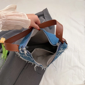 Retro denim tote bag with frayed edges, brown leather strap and spacious interior