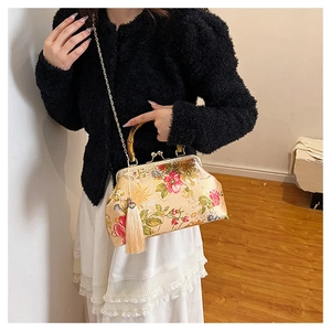 Détail d'un sac à main rétro en soie avec poignée en bambou et motifs floraux élégants