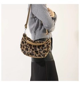 Detail of plush leopard print shoulder bag featuring premium faux fur and brown leather strap