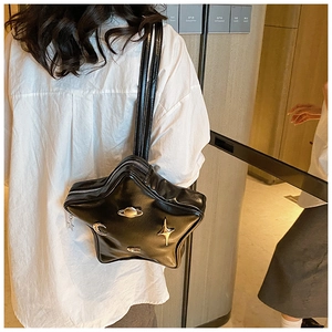 Detail of star-shaped black PU leather shoulder bag with gold moon and planet hardware