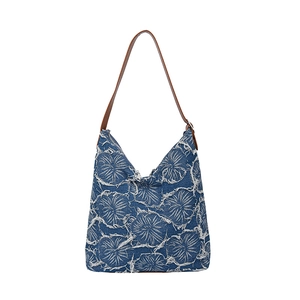 Vintage denim tote bag with leather straps and raw-edge floral design on white background