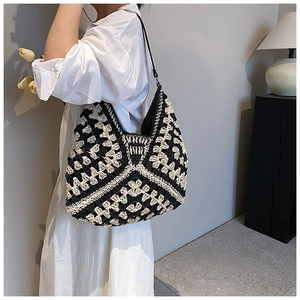 Close-up of crochet hobo bag with black and beige wave pattern and slim shoulder strap