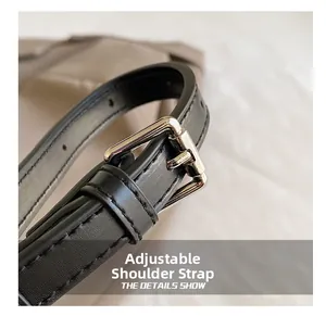 Detail of adjustable black leather shoulder strap with silver buckle and fine stitching