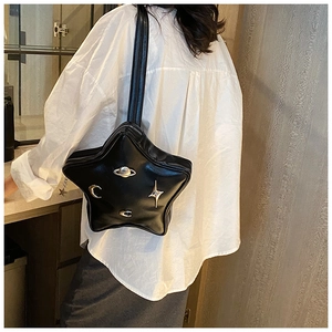 Detail of star-shaped crossbody bag with metallic Saturn and moon motifs on black leather