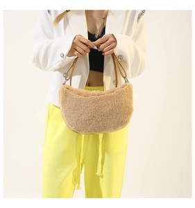 Close-up of camel faux fur texture on half-moon bag with silver metal buckles