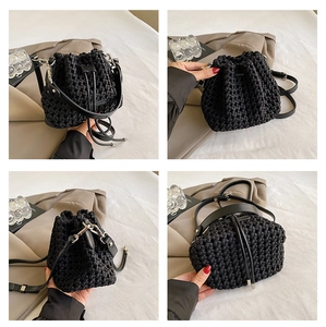 Detail view showing black woven bucket bag with drawstring closure and leather straps
