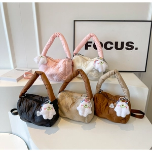 Multiple colors of quilted puffer handbags with cute plush charms on display