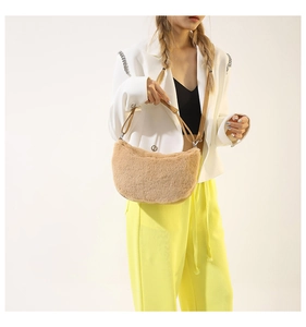 Detail of plush camel crescent bag with smooth faux fur texture and leather strap