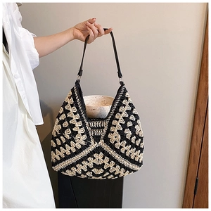 Detail of hand-woven geometric pattern contrast shoulder bag with black leather strap