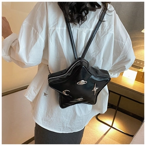 Detail of star-shaped black leather backpack with silver celestial metal ornaments