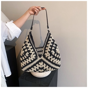 Detail of hand-woven hobo bag with black and white geometric crochet patterns