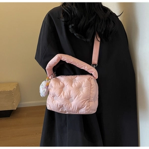 Detail of pink padded down bag with wide strap and cute plush bear charm decoration