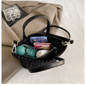 Interior view of black woven bucket bag showing capacity for phone, umbrella, and wallet