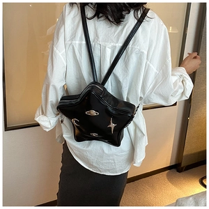 Close-up of black star-shaped backpack with silver metallic planet and moon charms