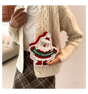 Detail of Christmas Santa crossbody bag featuring metal chain strap on a knit sweater