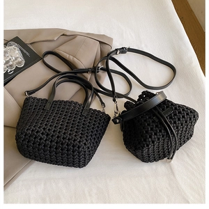 Detail of black woven tote and drawstring bucket bags with textured leather finish