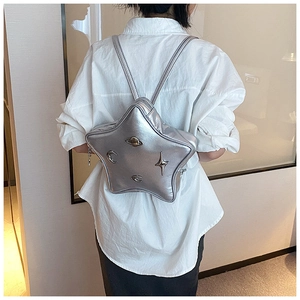 Detail view of the silver star-shaped backpack with metallic moon and planet hardware