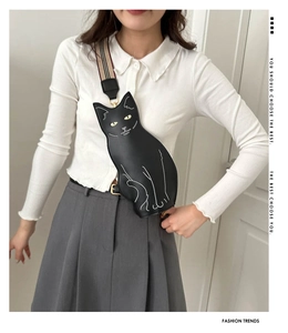 Detail of cute black cat chest bag showing white stitching and striped fabric strap