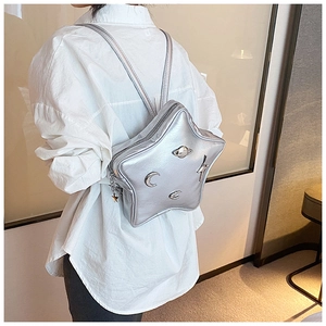 Close-up of a silver star-shaped backpack featuring 3D metallic cosmic ornaments