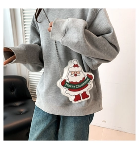 Detail view of a Santa Claus crossbody bag with silver ball chain strap on a model