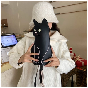 Detail of cute black cat crossbody bag with facial embroidery and striped shoulder strap