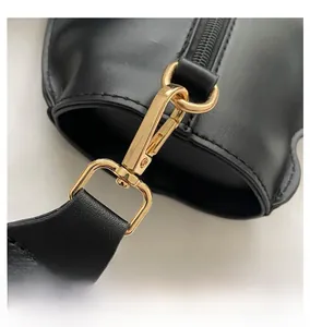 Detailed close-up of premium gold metal lobster clasp on a black leather cat crossbody bag