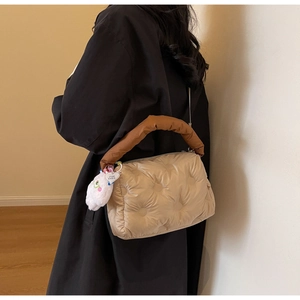 Detailed quilted puffer crossbody bag featuring a soft plush bunny charm and brown handle