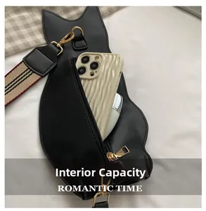 Internal capacity of cat-shaped crossbody bag showing phone storage and striped strap