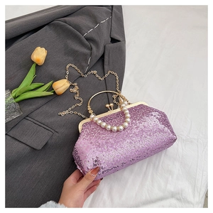 Close-up of purple sequin evening clutch with pearl handle and gold metal lock