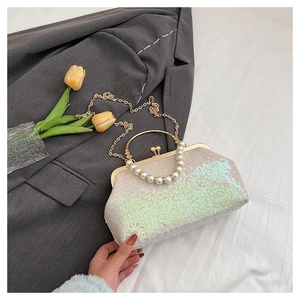 Detail of evening sequin handbag featuring pearl handle and gold chain strap