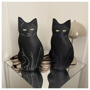 Detail of cute cat-shaped crossbody bags with adjustable striped fabric shoulder straps