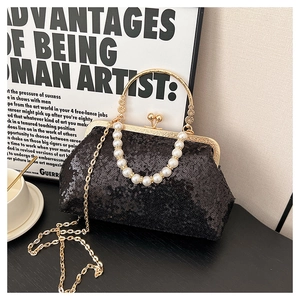 Close-up of elegant black sequin evening bag with gold metal frame and pearl chain strap