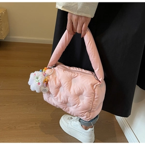 Detail of pink quilted down bag featuring soft texture and fluffy cloud charm with heart tag