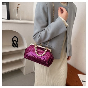 Close-up of fuchsia sequin handbag with pearl handle and detachable gold chain