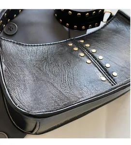 Detail view of black vintage rivet shoulder bag with soft leather texture and gold studs