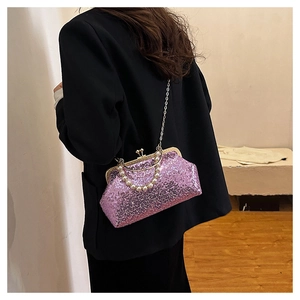 Pink sequin crossbody bag with pearl handle worn by a model in a black blazer suit