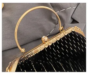 Detail of vintage shell bag with gold engraved floral hardware and a ring handle