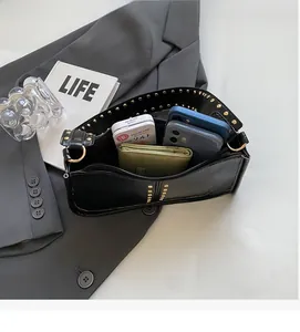 Detail view of the spacious inner compartment of the black studded shoulder bag with zipper