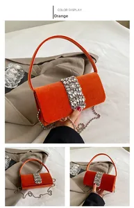 Detail of orange velvet evening bag with sparkling rhinestones and metal chain