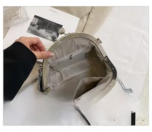 Detail of black shell bag showing grey herringbone lining and internal zipper pockets