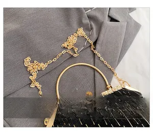 Close-up of black velvet shell bag featuring vintage gold handles and chain strap