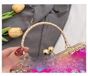 Close-up of pink satin embroidery handbag with golden metal handle and rhinestone details