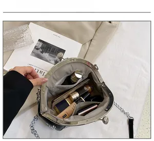 Detail view showing large interior capacity of black shell bag with silver chain strap