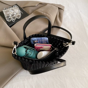 Woven tote bag in black featuring dual handles and a long shoulder strap for daily commuting