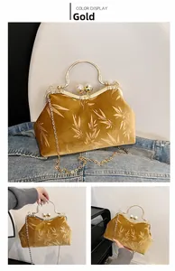 Macro detail of gold velvet evening clutch with kiss-lock clasp and pearl decoration