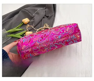 Detailed base of rose red silk embroidery evening bag with golden chain strap