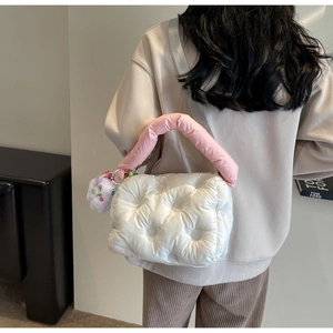 Detail of white puffer handbag with pink plush handle and cute bear charm pendant