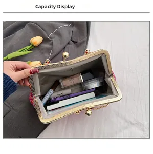 Internal capacity of red floral embroidered evening bag showing phone and cosmetics